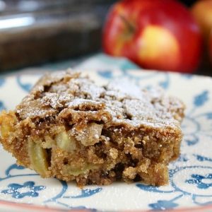 slice of apple cake on a plate, apple in background