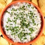 Bowl of spinach dip with tortilla chips.