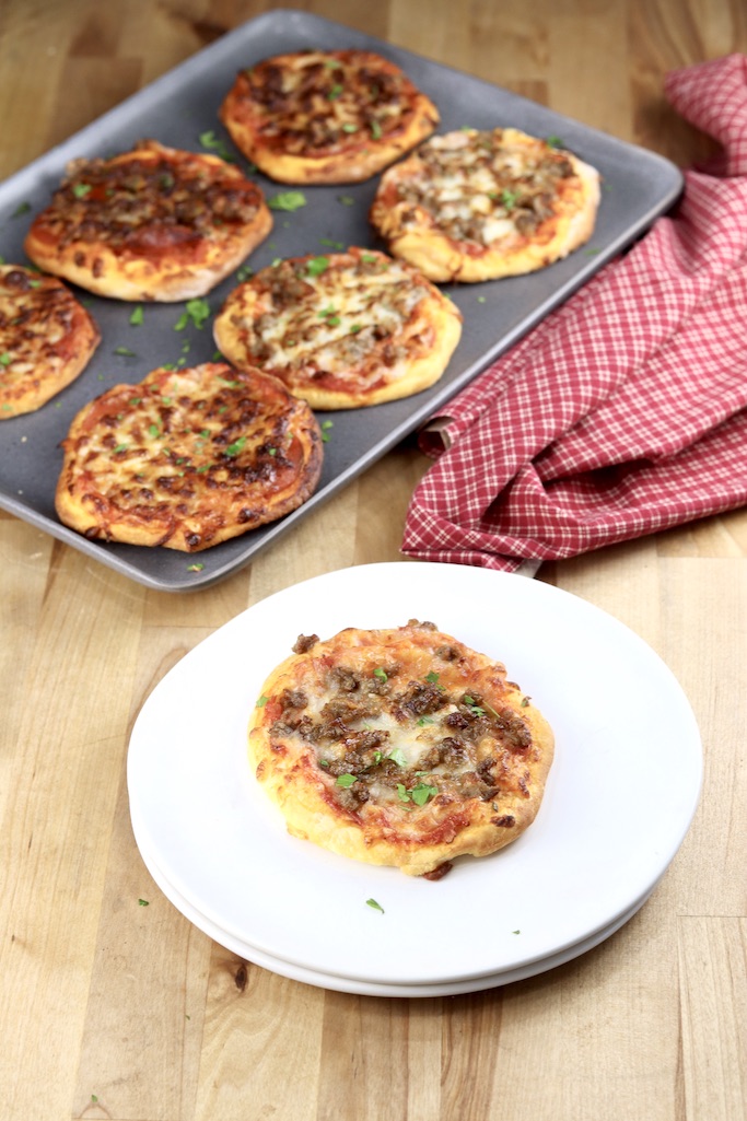 mini pizzas on a pan + one on a white plate.