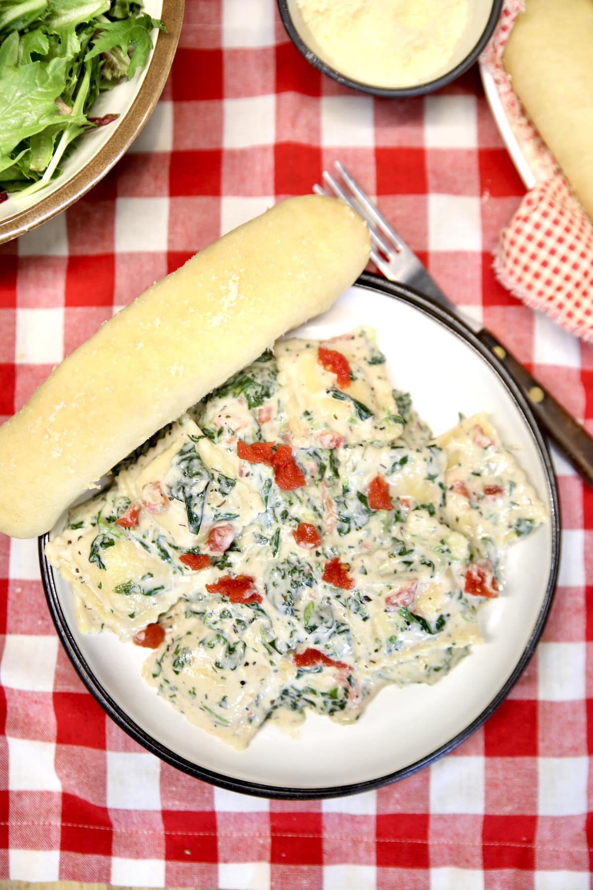 Plate of pasta with a breadstick.