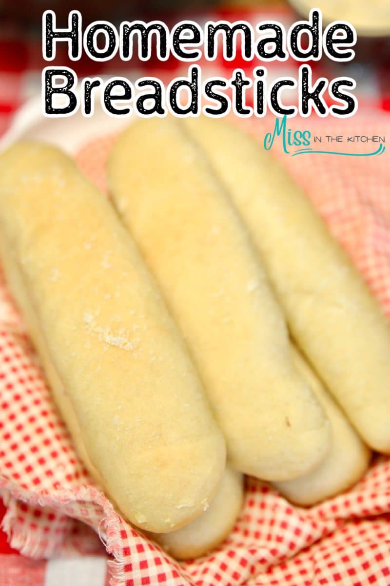 Breadsticks on a red check napkin.