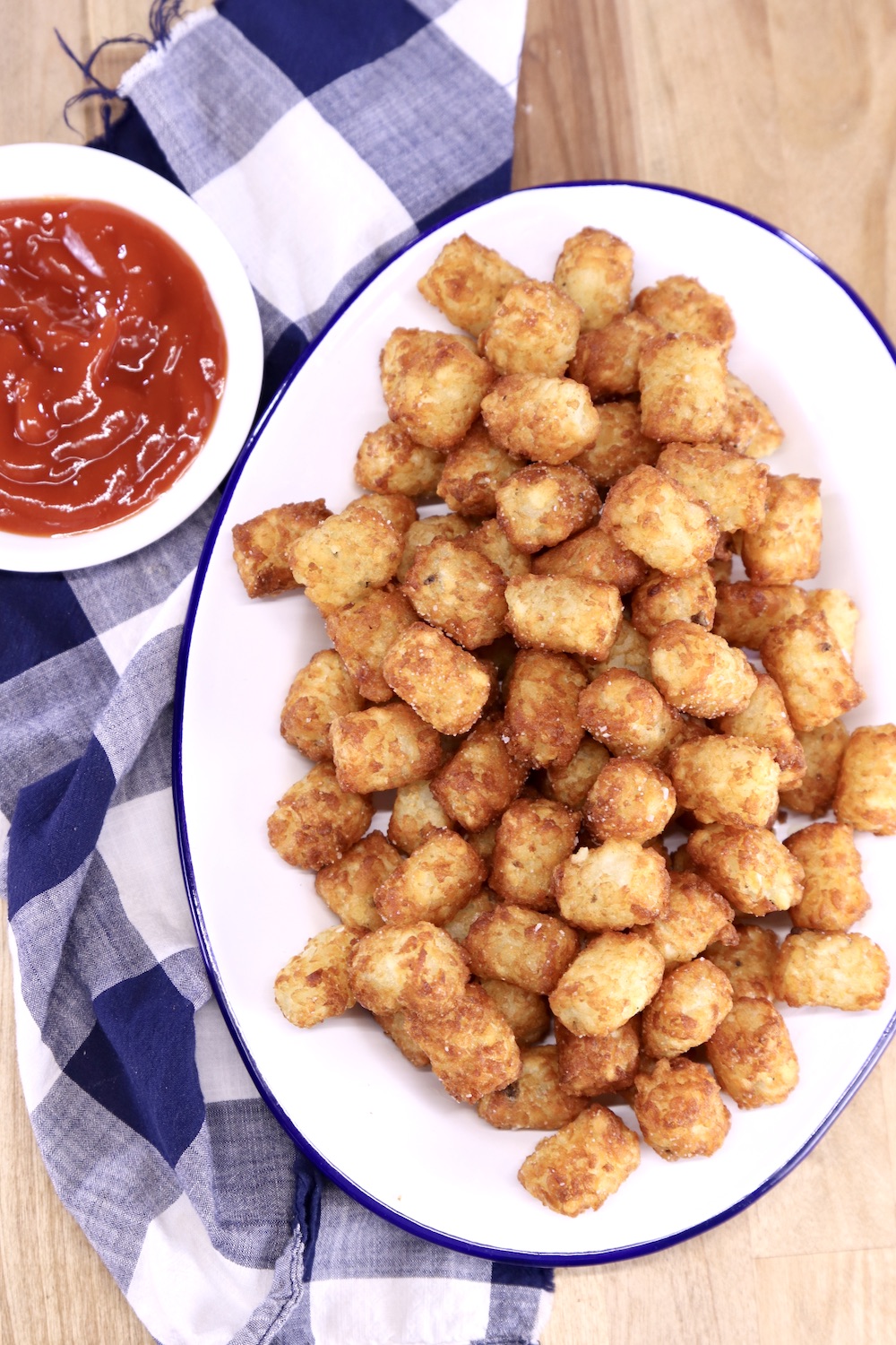oval platter of tater tots with small bowl of ketchup