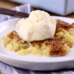 plate of pineapple dump cake served with vanilla ice cream