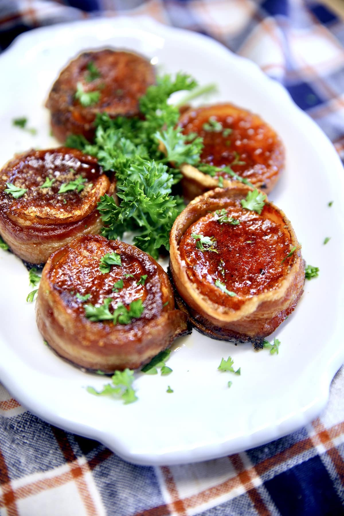 Bacon wrapped sweet potatoes on a plate.