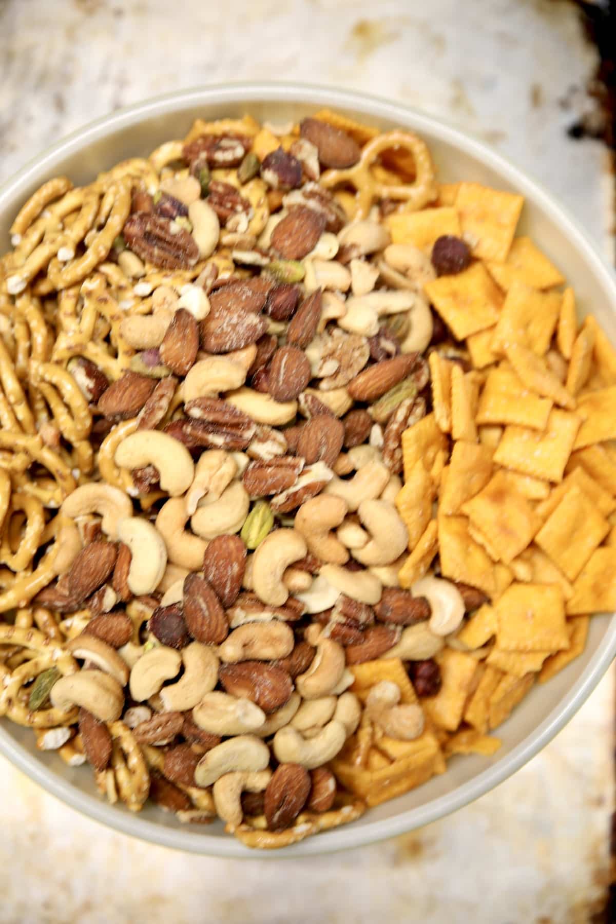 Bowl of cheese crackers, pretzels, nuts.