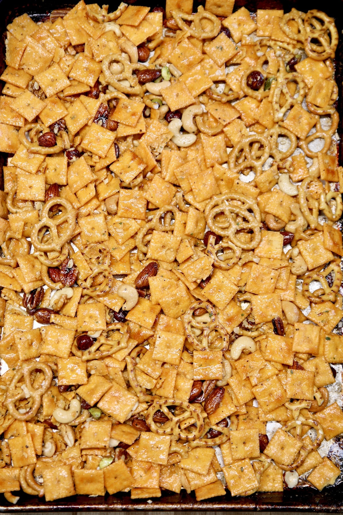 Cheez-It snack mix on a sheet pan with nuts and pretzels.