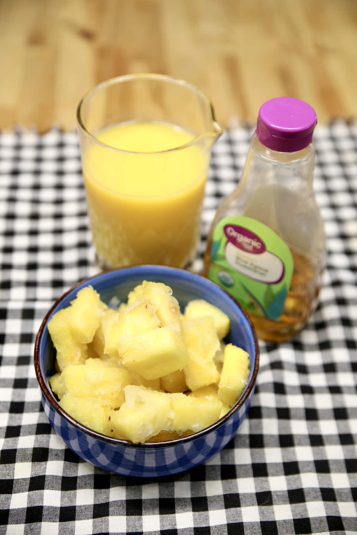 Ingredients for pineapple smoothie: orange juice, agave syrup and pineapple.