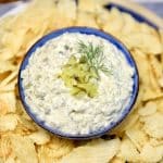 Pickle dip in a bowl with potato chips.