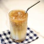 Iced caramel macchiato in a glass with a straw.