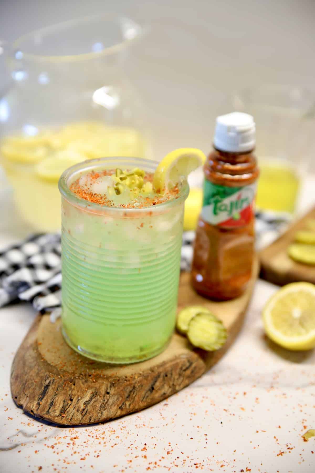 Pickle lemonade in a glass with Tajin seasoning garnish.