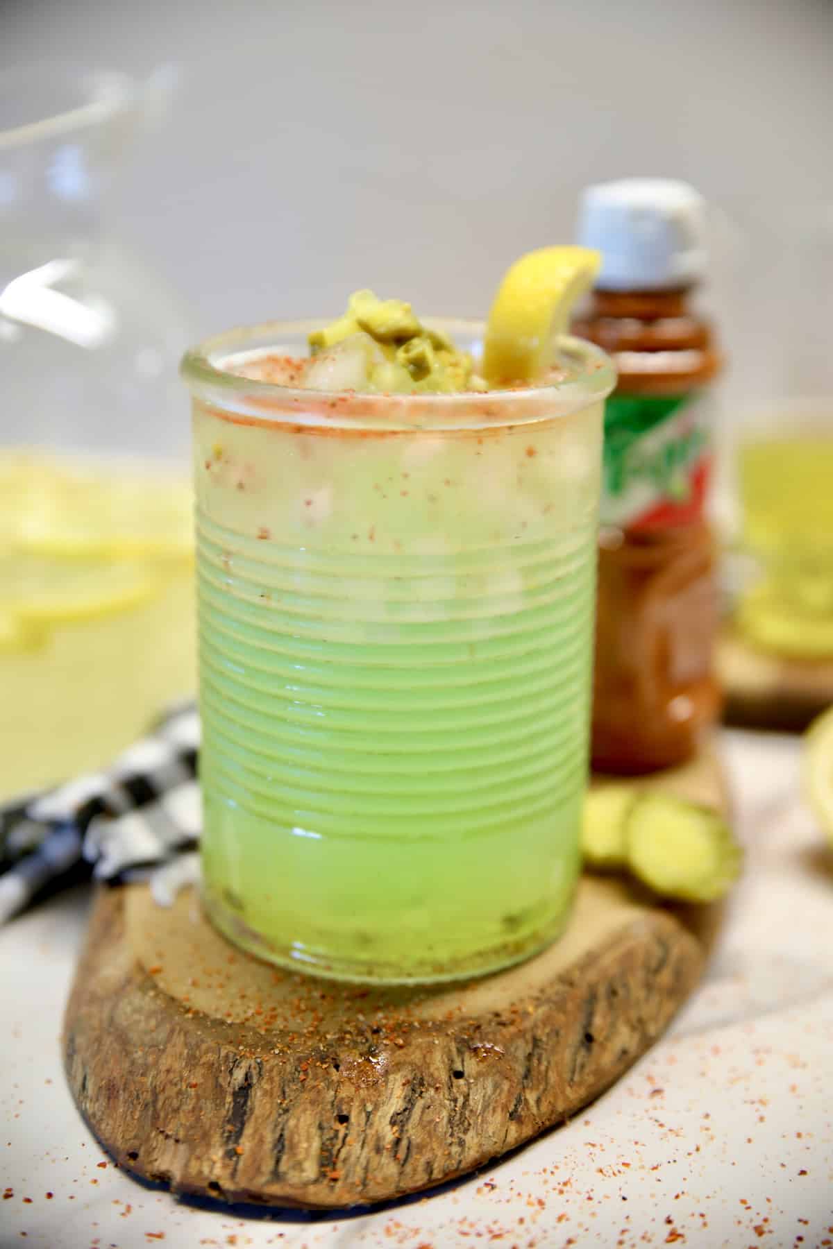 Pickle lemonade in a glass on a slice of wood.