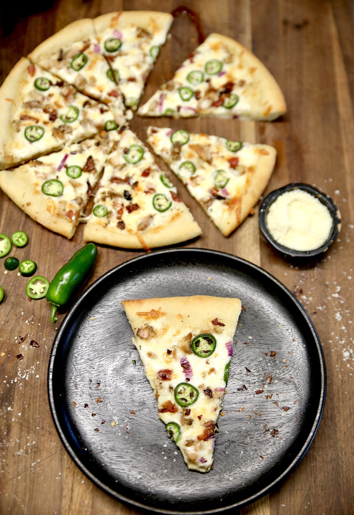 Pizza with chicken and bacon, slice on a plate.