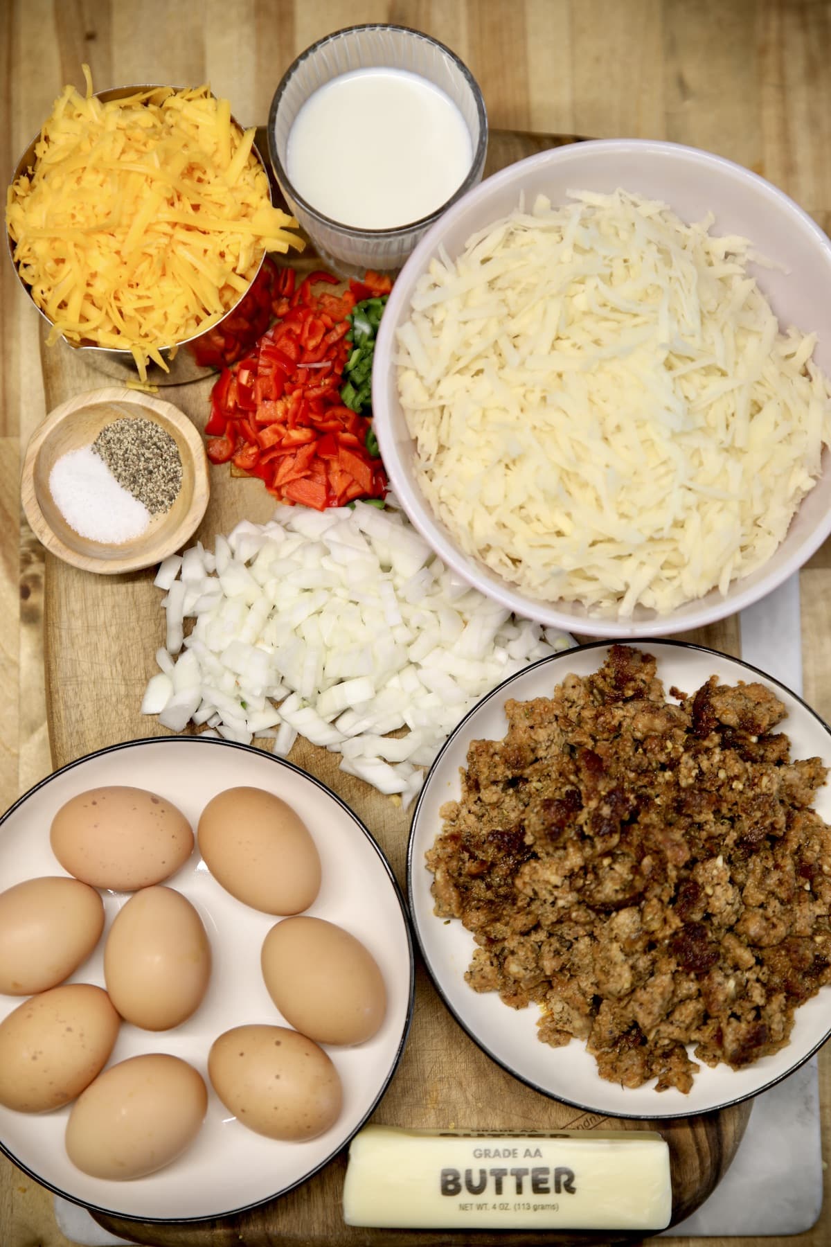 Ingredients for breakfast casserole with hashbrowns, eggs, cheese and sausage.