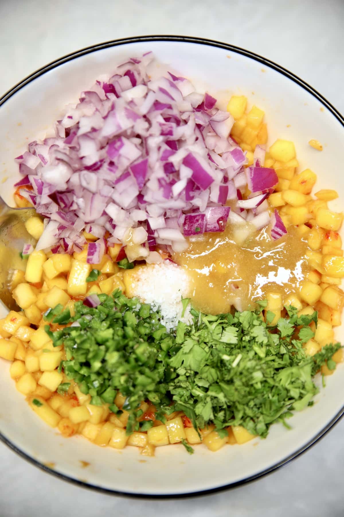 Bowl of ingredients to make fresh peach salsa.