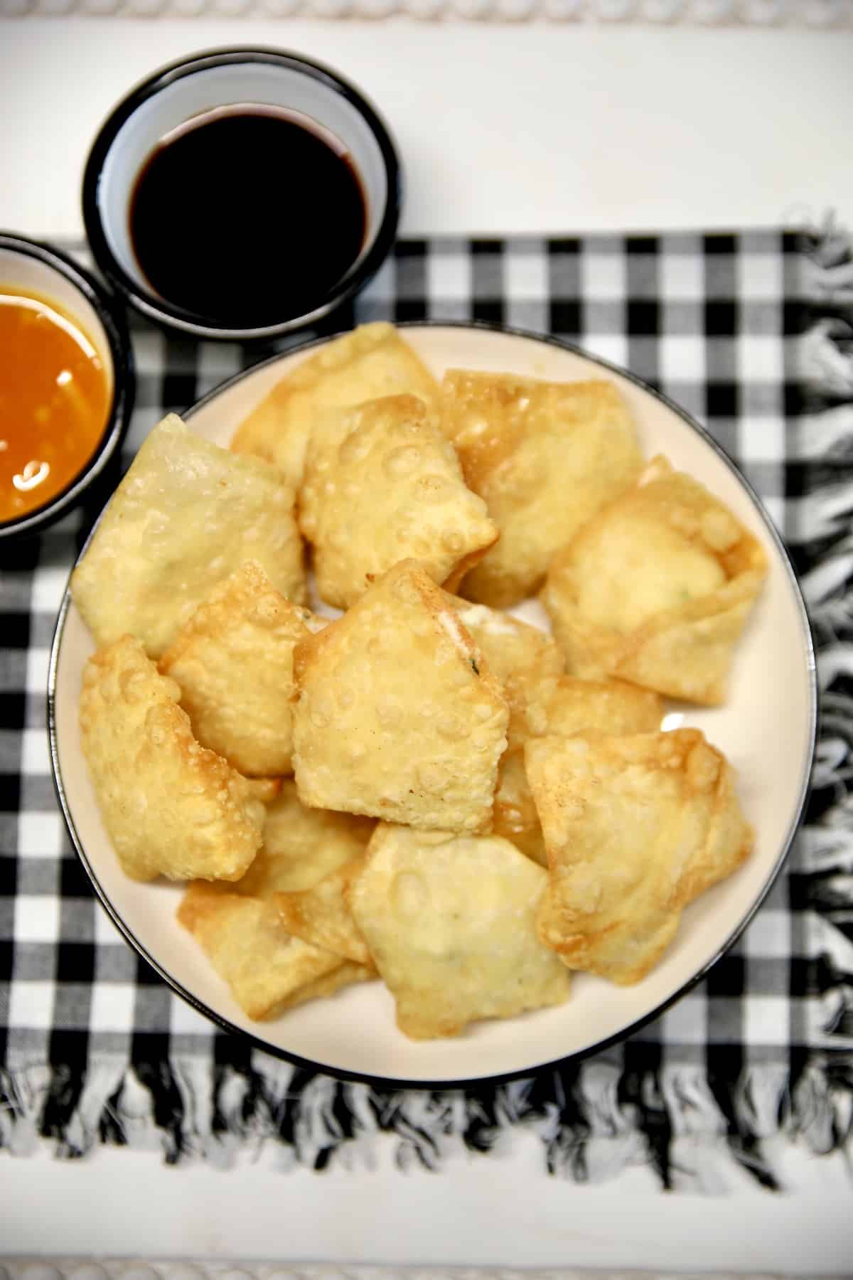 Shrimp Rangoon on a platter with soy sauce.