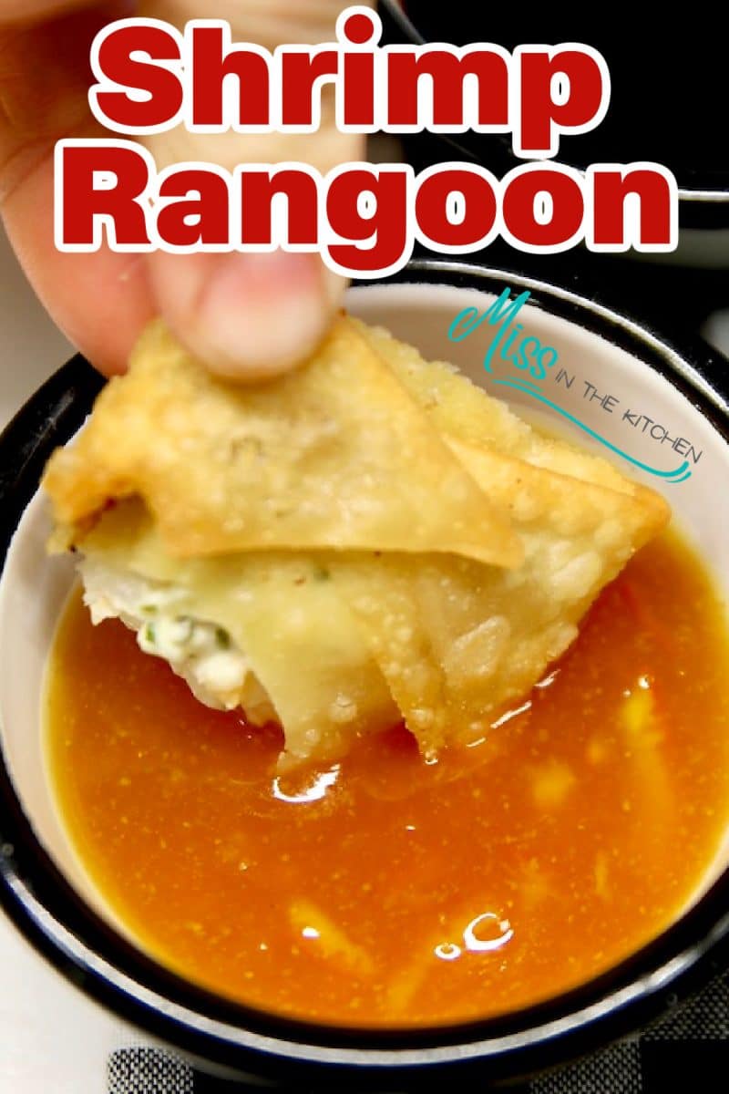 Shrimp rangoon dipping into orange sauce - text overlay.