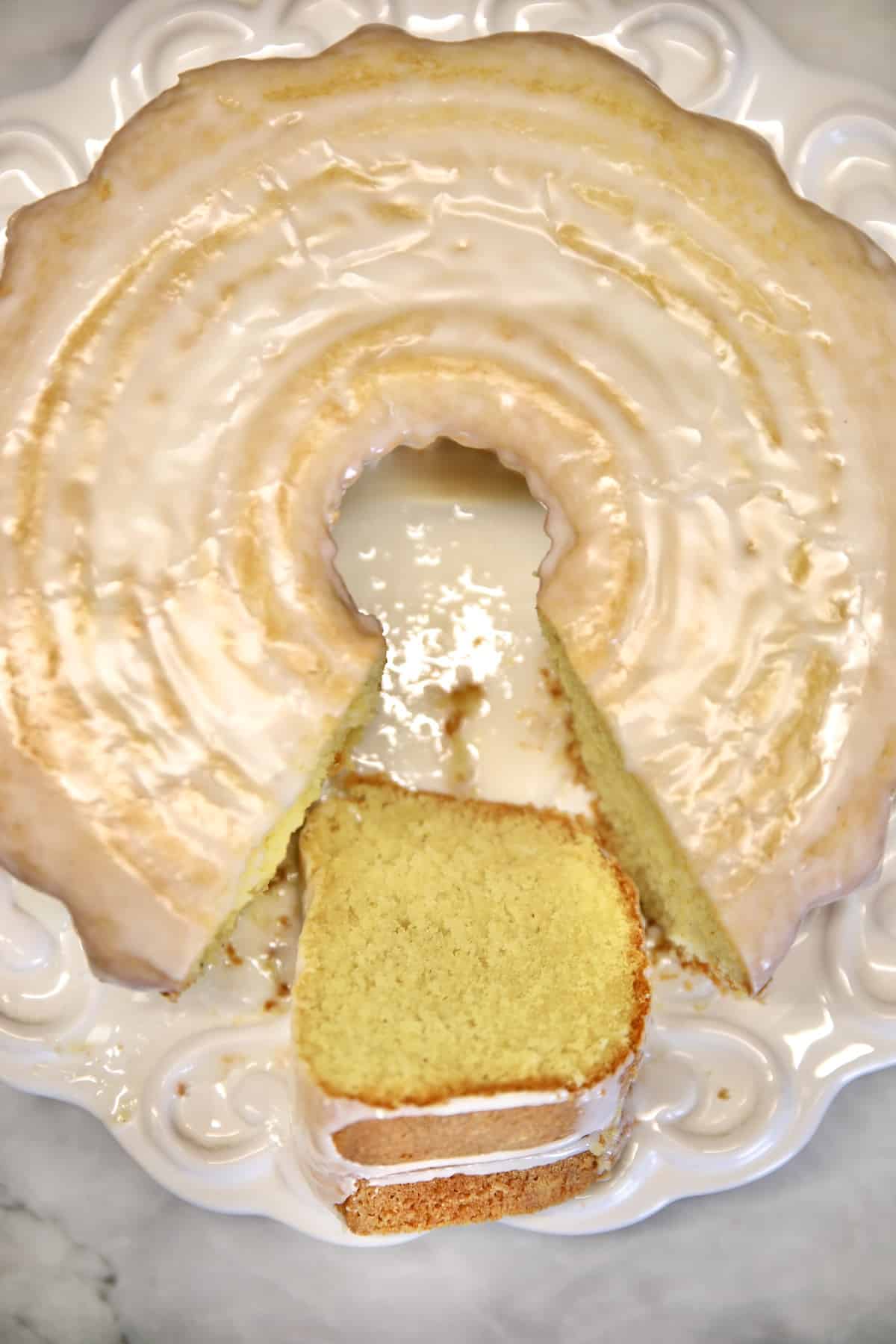 Glazed Donut Cake on a plate with one slice cut.