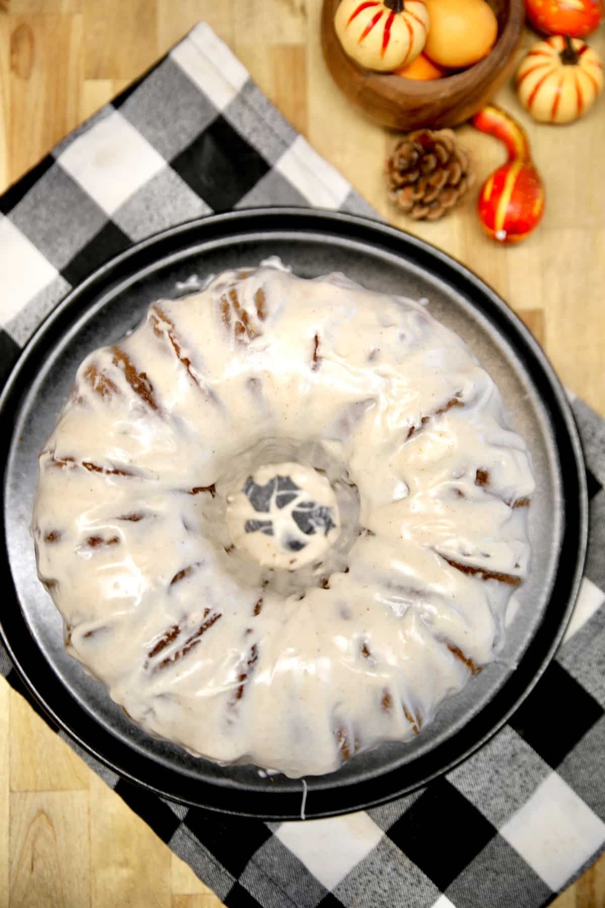 Pumpkin bundt cake with cream cheese icing on a plate.