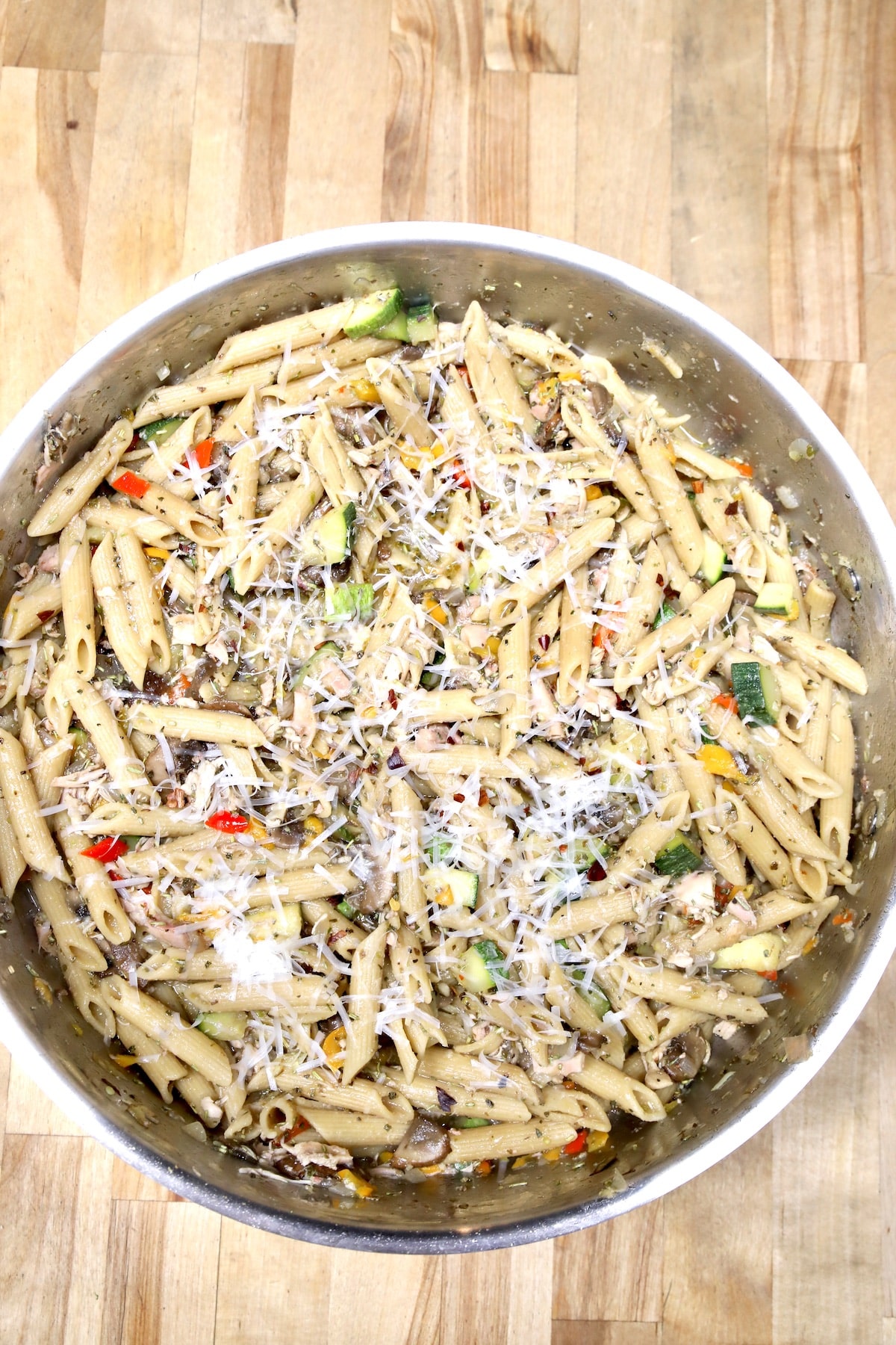 Pasta with vegetables in a round pan.