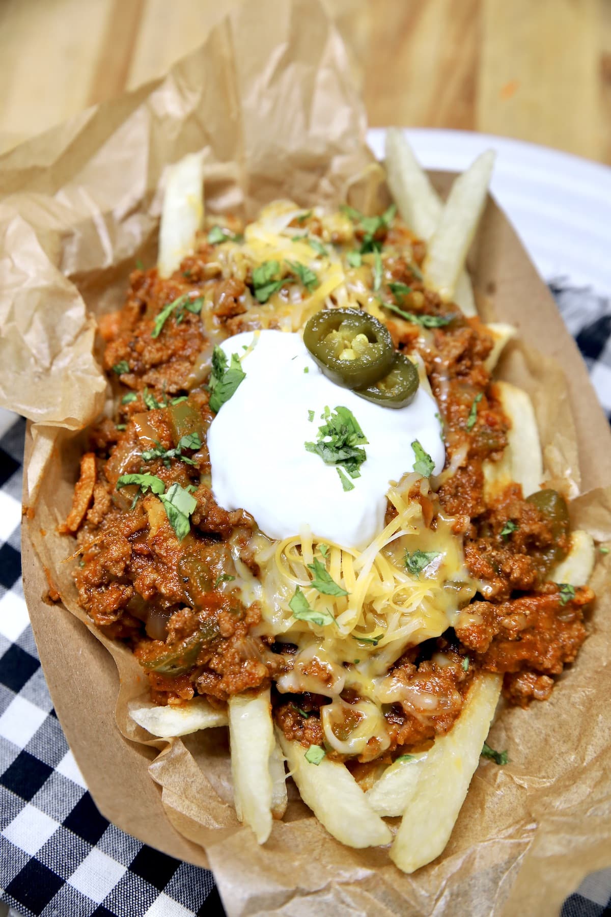 Boat of chili cheese fries with sour cream and jalapenos.