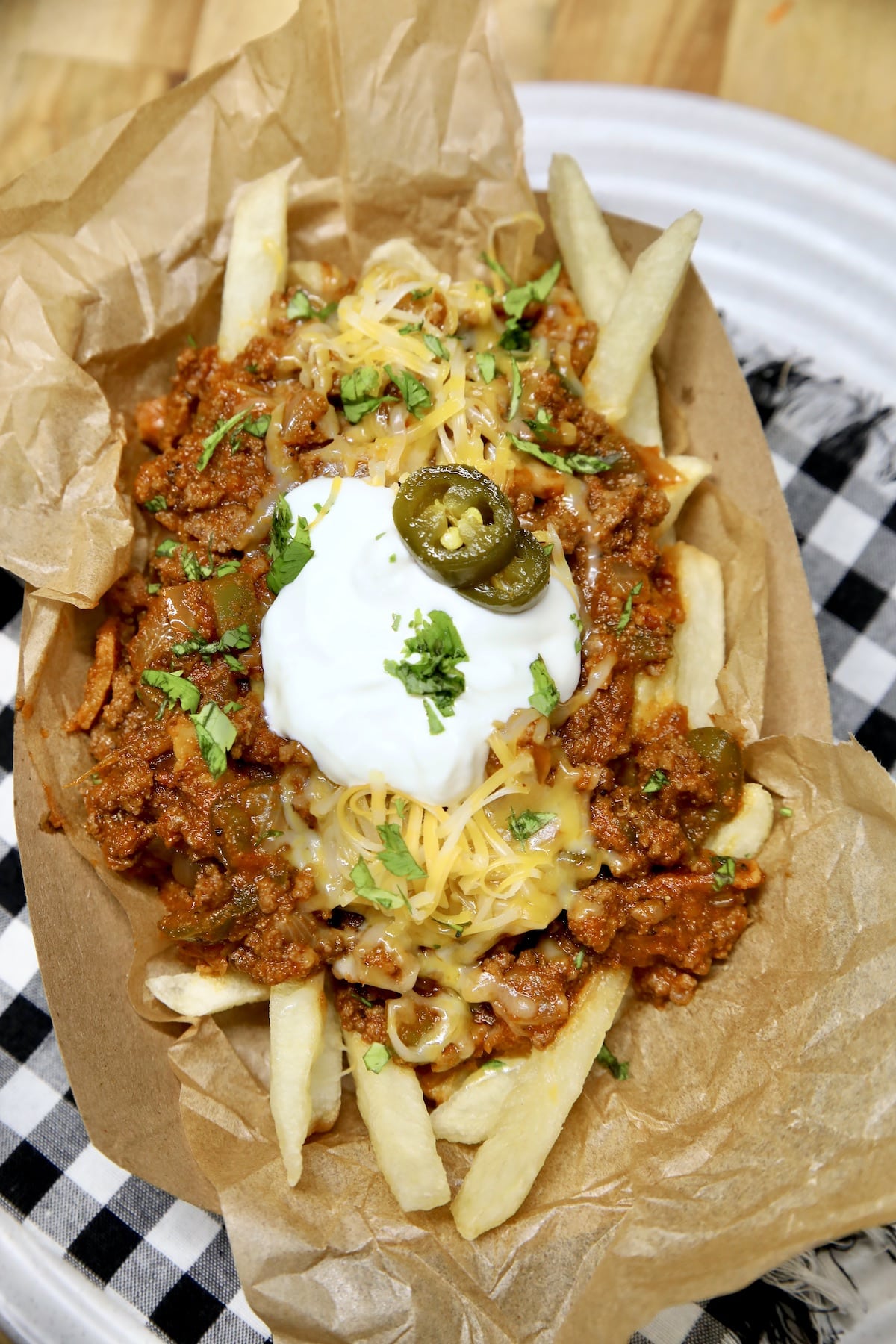 Boat of chili fries with cheese, sour cream and jalapenos.