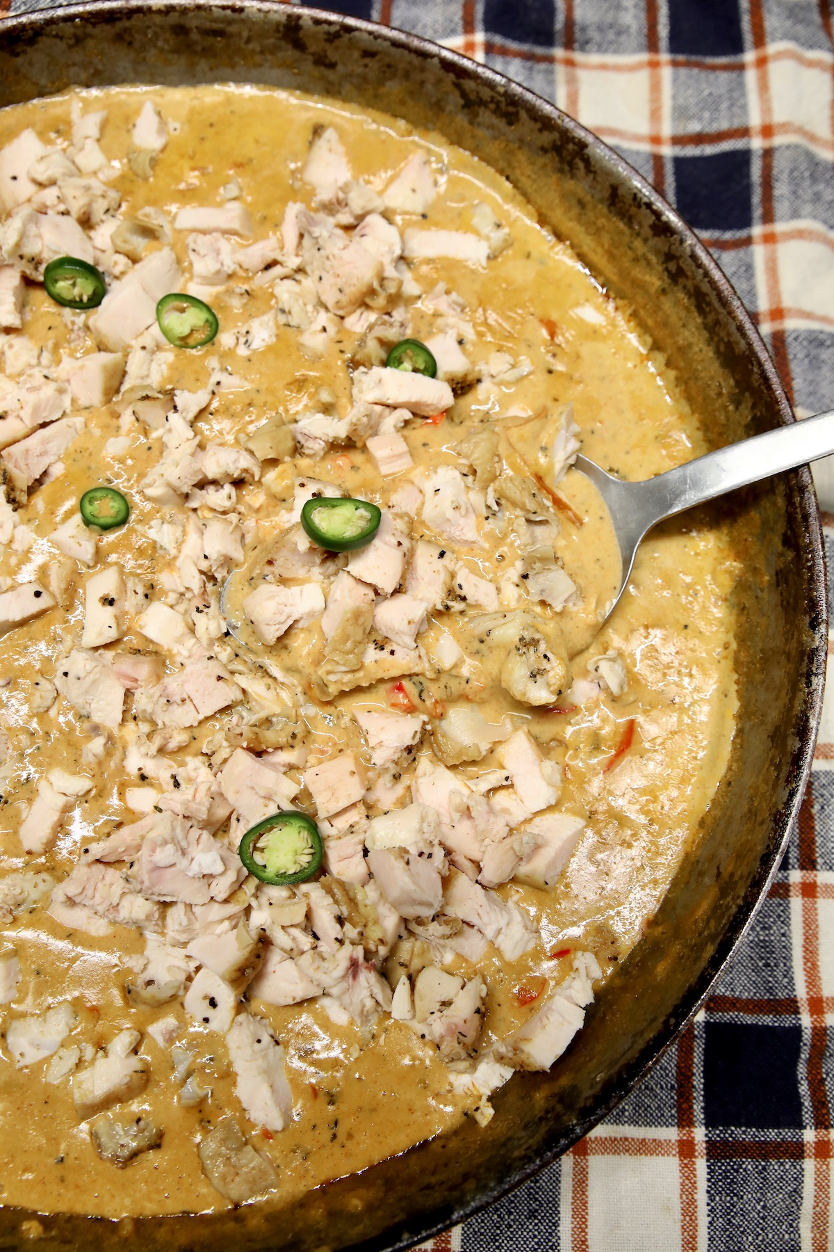 Skillet of cajun chicken in cream sauce with jalapenos.