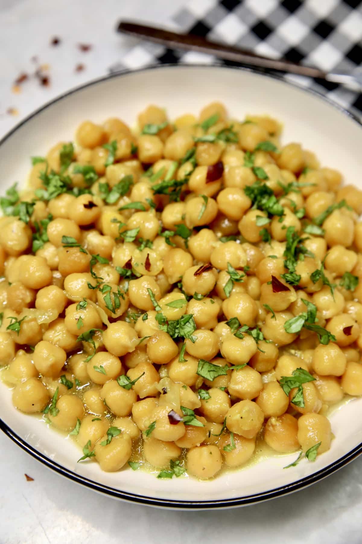 Bowl of chickpeas with cilantro and chili flakes.