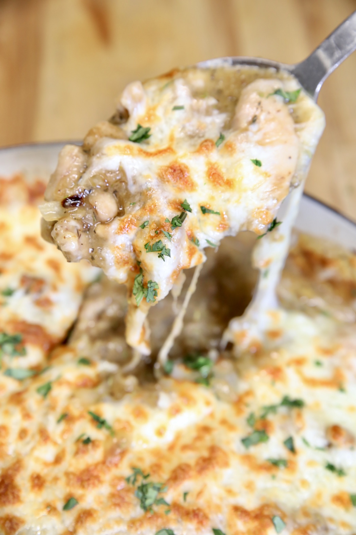 Spoonful of chicken with melted cheese.