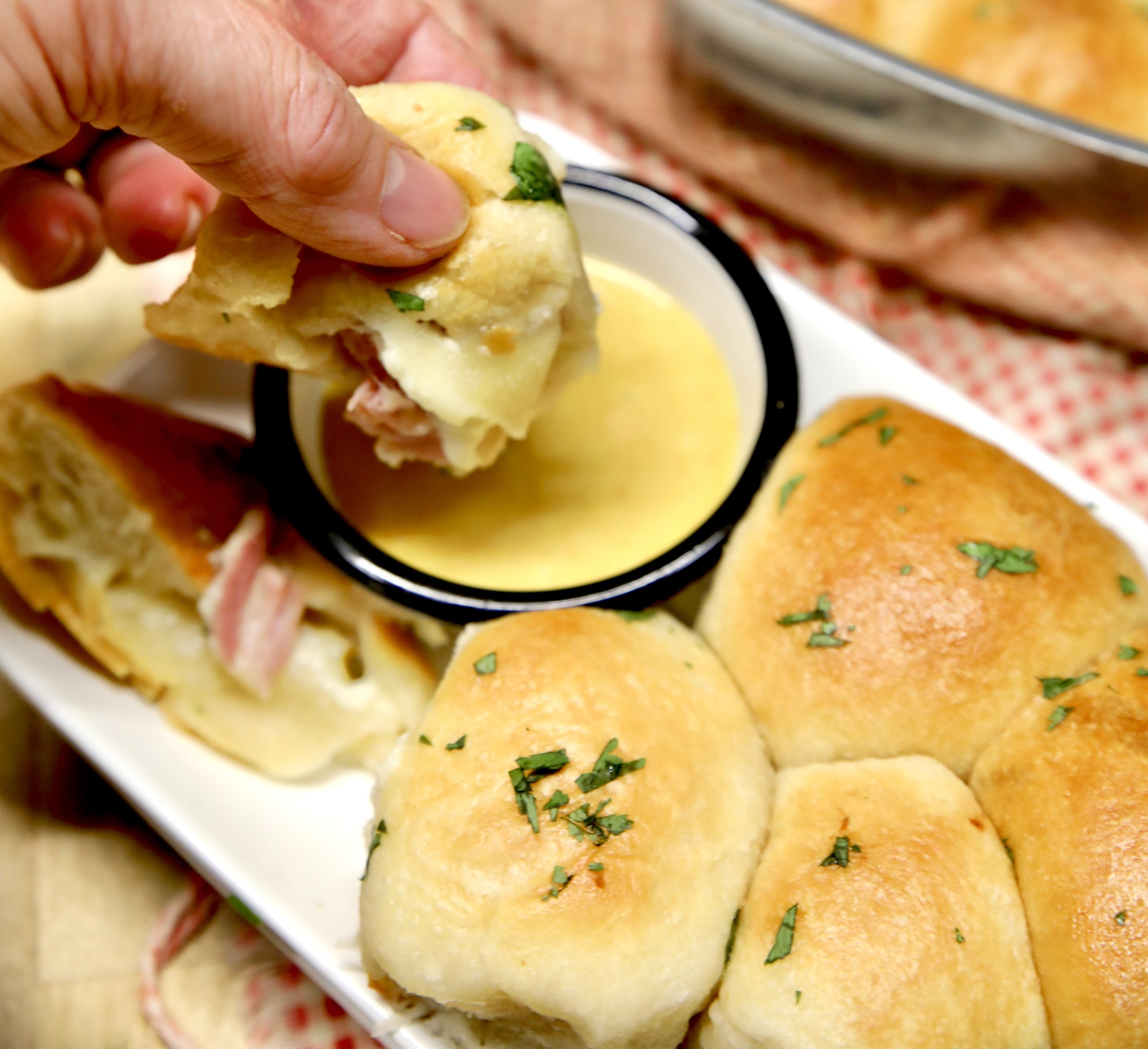 Dipping ham and cheese biscuit into honey mustard.