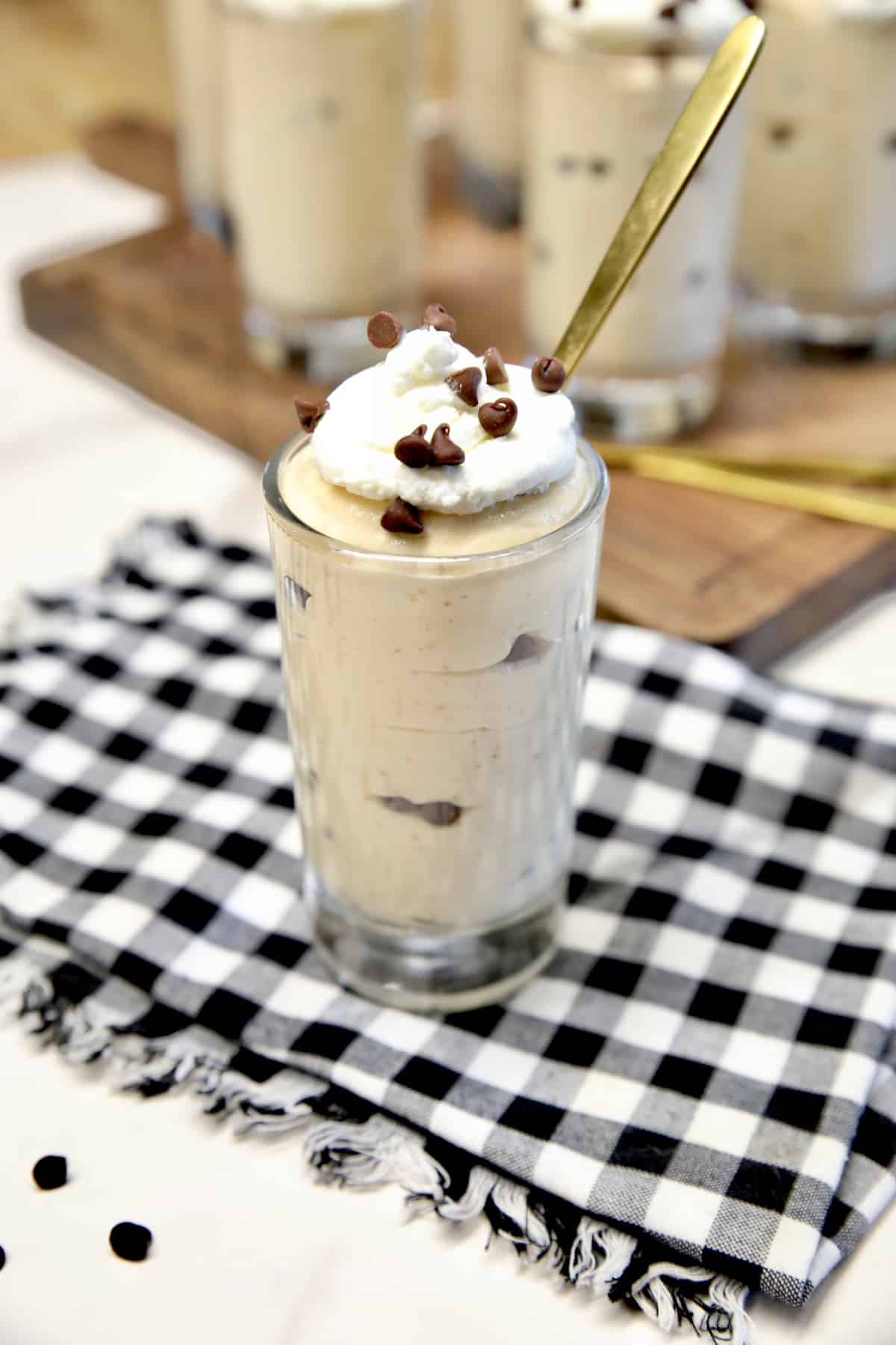 Peanut butter cheesecake in a dessert glass with spoon.