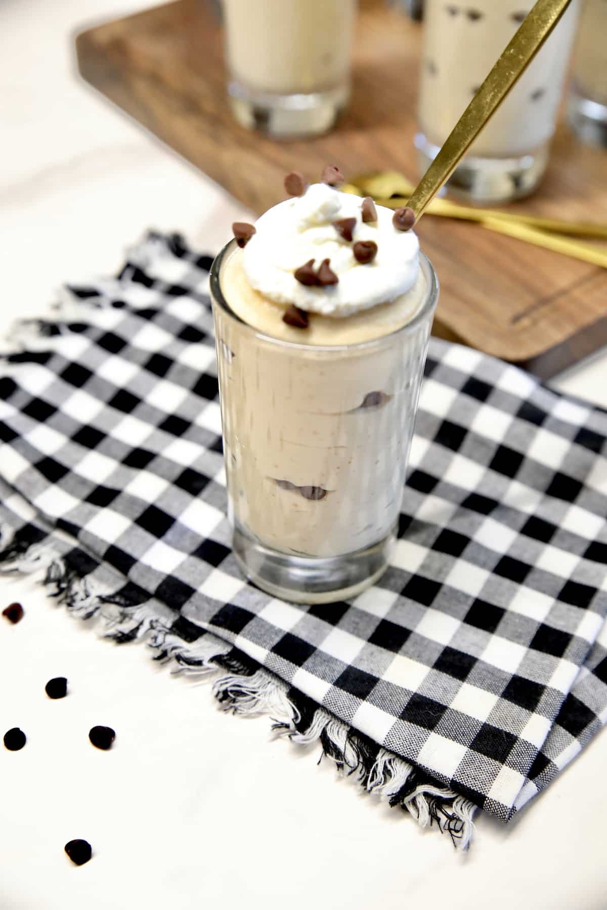 Glass of peanut butter cheesecake with mini chocolate chips.