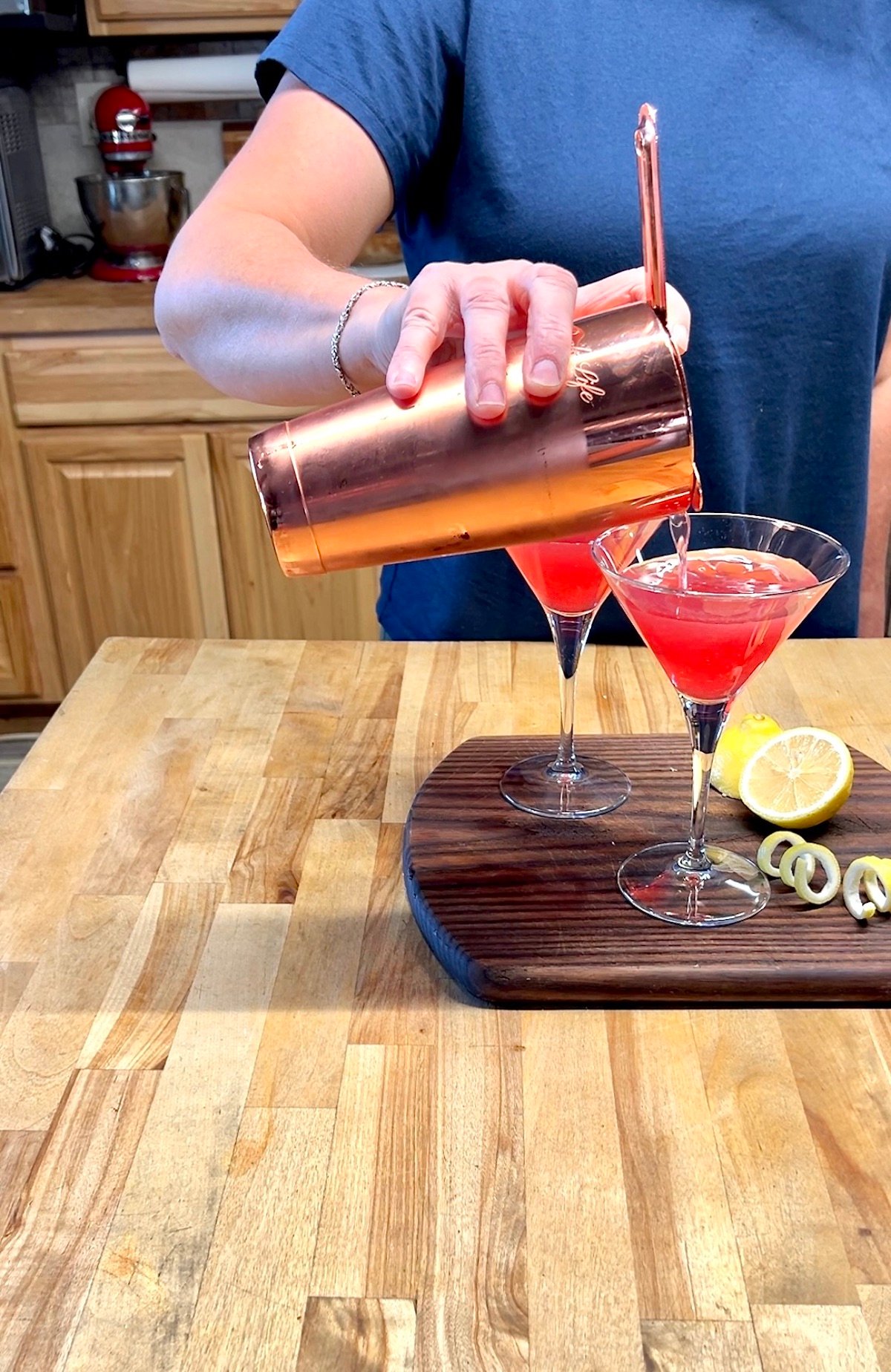 Cranberry cocktail straining from shaker to glasses.