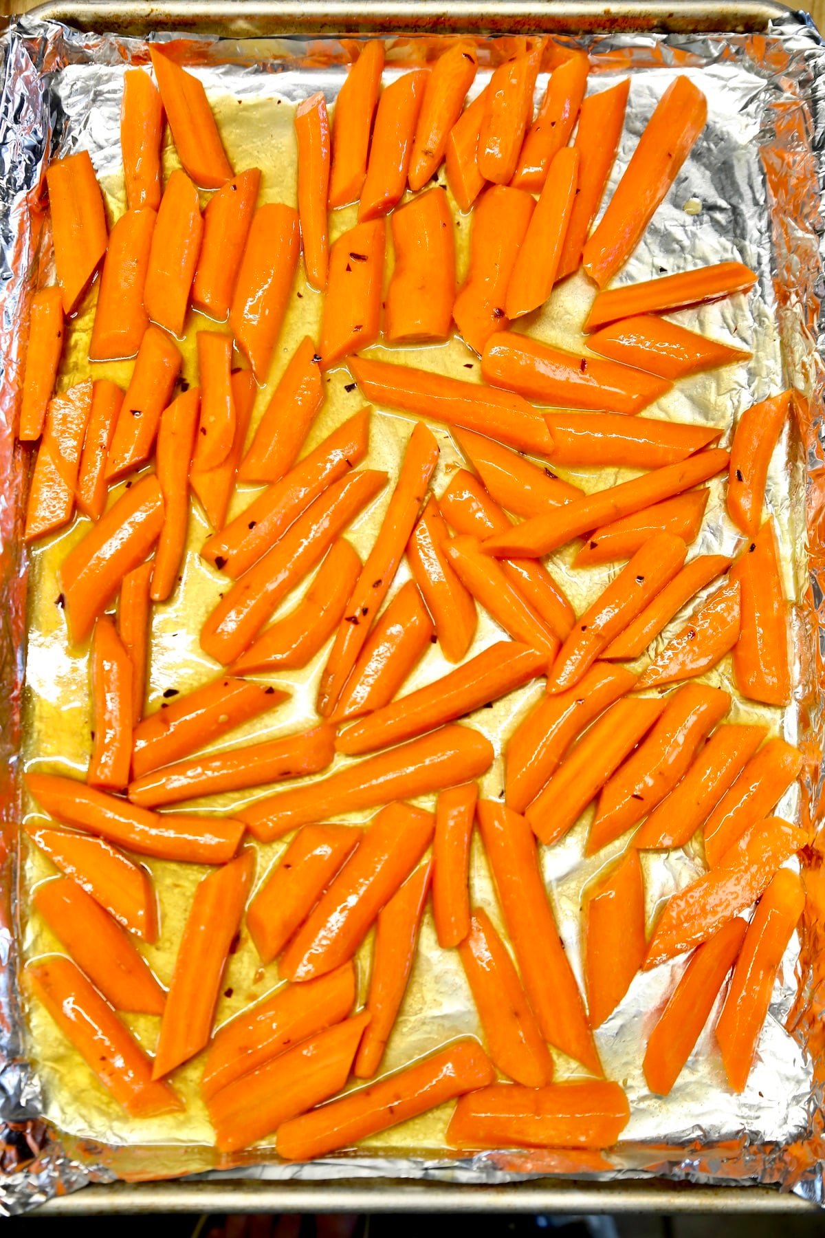 Carrots with butter and maple syrup on a sheet pan.